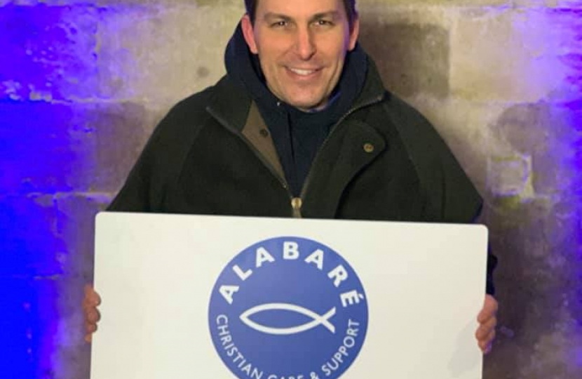 John holding an Alabaré⁩ sign